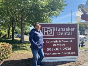 Patient outside of Hunsaker standing in front of Advertised sign