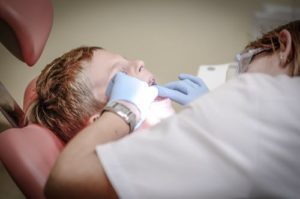 child in dentist chair teeth check